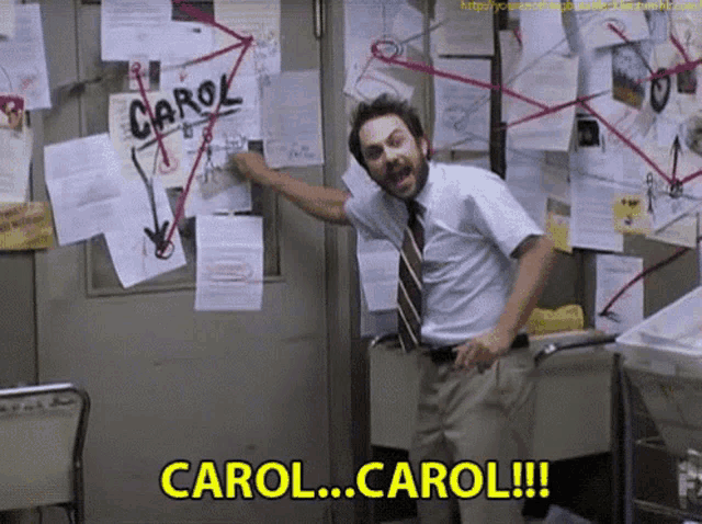 a man is standing in front of a bulletin board that says carol on it