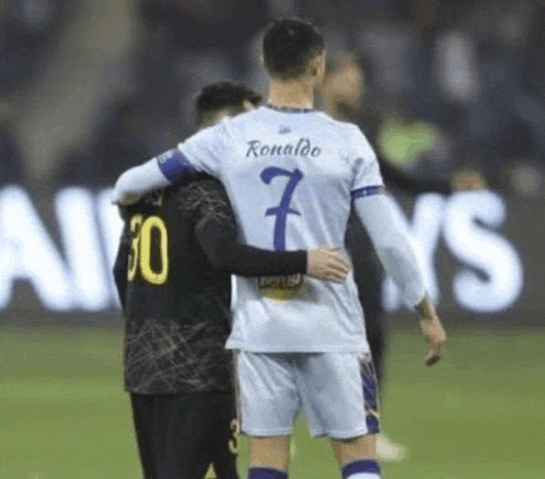 a soccer player with the number 7 on his back is hugging another player on the field .