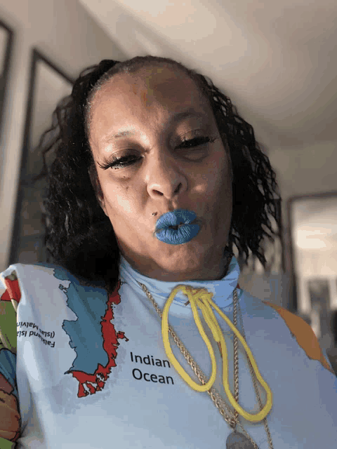 a woman wearing a shirt that says indian ocean blows a kiss