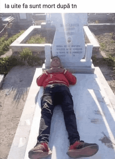 a man is laying on a grave with the words la uite fa sunt mort dupa tn