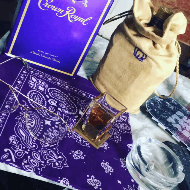 a bottle of crown royal sits on a purple bandana