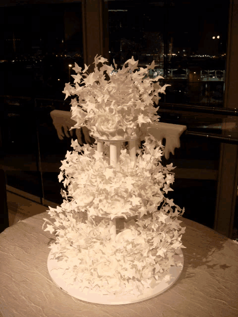 a wedding cake with white flowers and stars on it