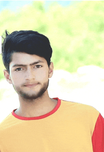 a young man wearing a yellow shirt with a red collar