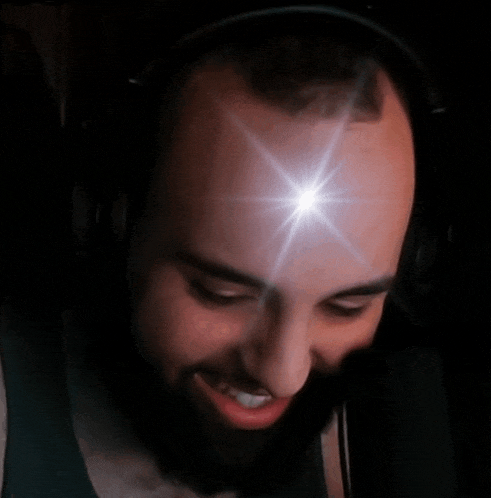 a man with a beard wearing headphones has a light shining on his head