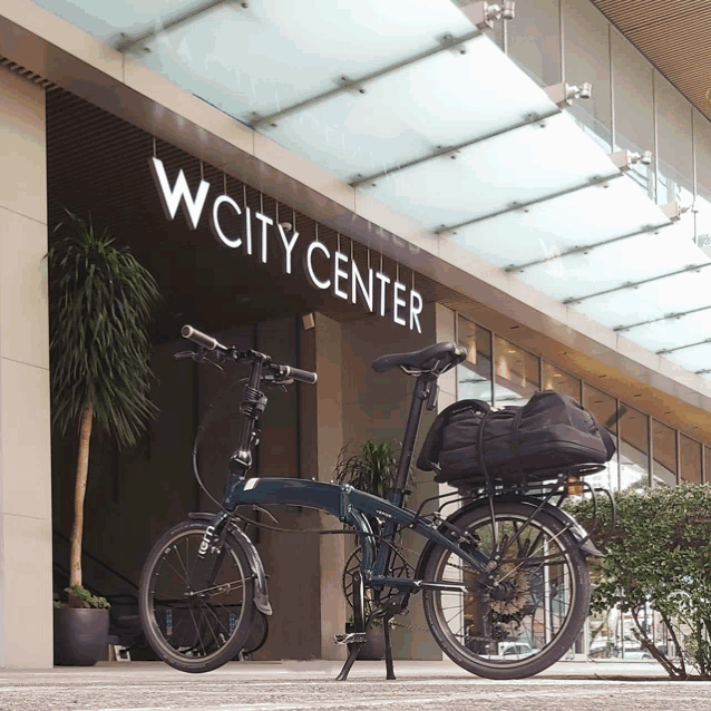 a bicycle is parked in front of a building that says wcity center