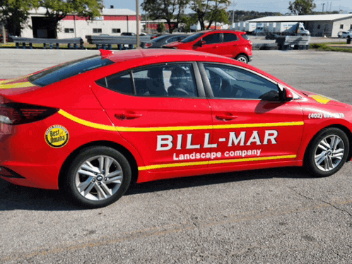 a red car with bill mar landscape company written on the side