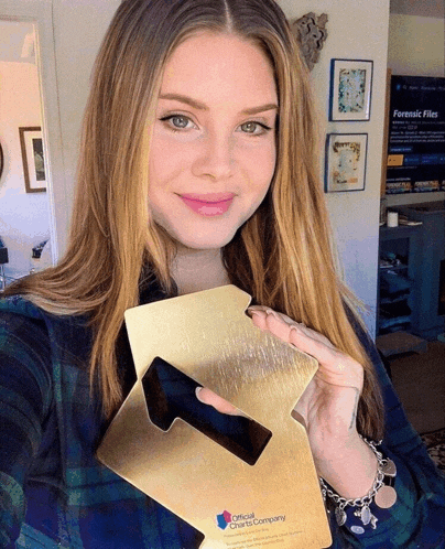 a woman is holding a gold plaque that says critical clear to company