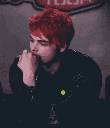 a man with red hair is wearing a black jacket