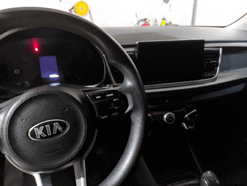 the interior of a kia car with a steering wheel and a dashboard