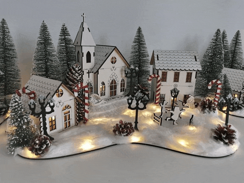 a christmas village with a church and candy canes in the snow