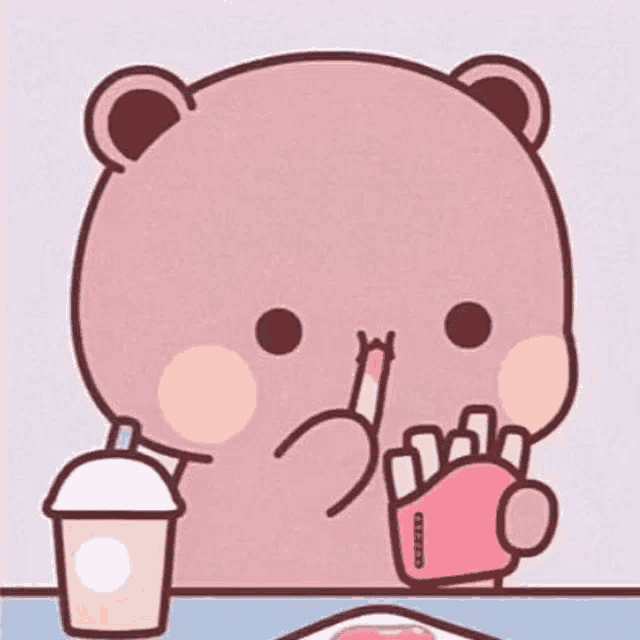 a teddy bear is sitting at a table eating french fries and drinking a cup of coffee .