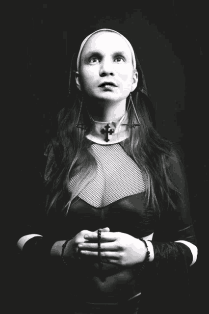 a black and white photo of a nun with a cross on her neck