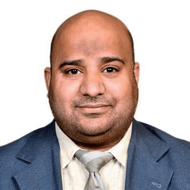 a bald man wearing a suit and tie is smiling .