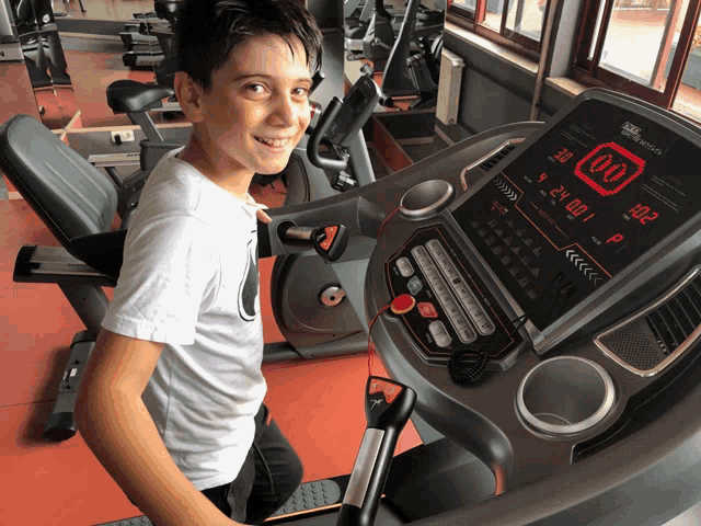 a boy is on a treadmill with the number 00 on the screen