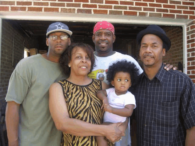 a man wearing a blue hat with a star on it holds a baby