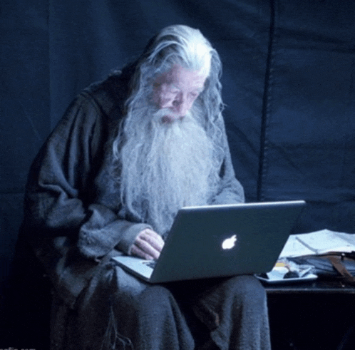 a man with a long beard is using an apple laptop computer