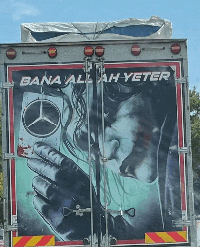 a mercedes truck has a painting of a woman kissing a man on the back of it