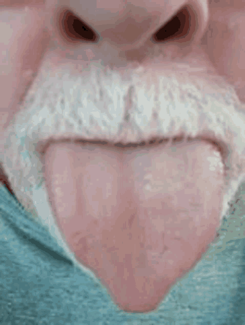 a close up of a man 's mouth with his tongue out .