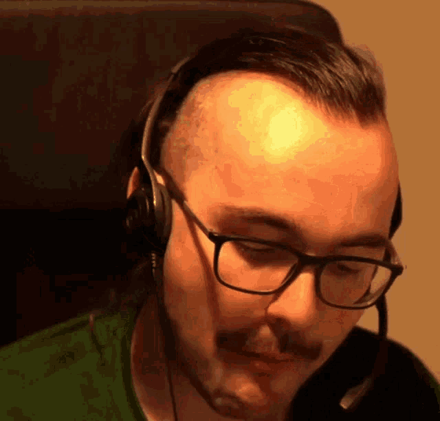 a man wearing glasses and headphones looks down