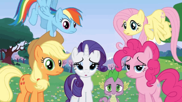 a group of ponies are standing in a field with one looking sad