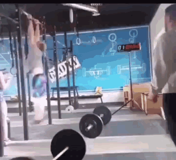 a man is lifting a barbell in a gym with a sign that says ' god 's '