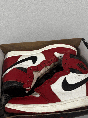 a pair of red and white nike air jordans are sitting in a box