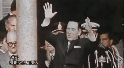 a man in a suit and tie is waving his hand in front of a crowd of people in buenos aires .