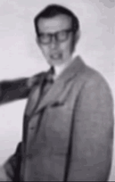 a blurry picture of a man in a suit with glasses