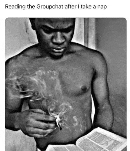 a black and white photo of a shirtless man smoking a cigarette and reading a book