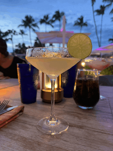 a margarita in a martini glass with a lime slice