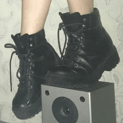 a pair of black boots are sitting on a speaker