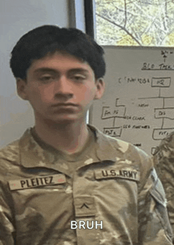 a man in a u.s. army uniform is standing in front of a white board