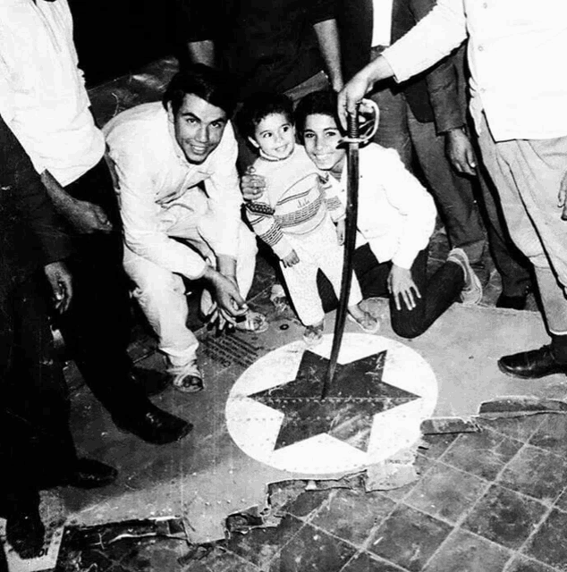 a group of people are gathered around a star on the floor