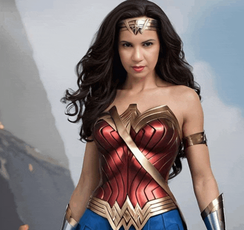 a woman in a wonder woman costume is standing in front of mountains