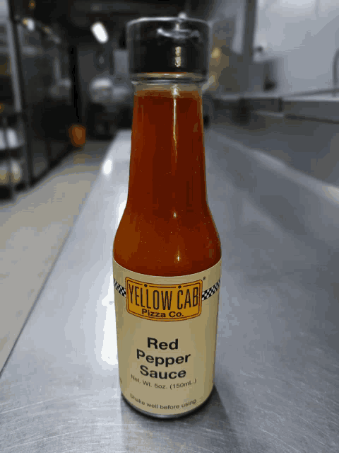 a bottle of red pepper sauce from yellow cab pizza co