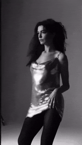 a black and white photo of a woman in a metallic dress and tights .