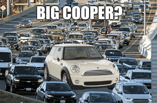 a white mini cooper is driving through a traffic jam