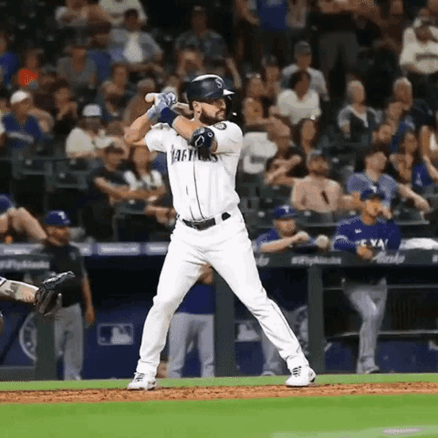 a baseball player is swinging a bat at a pitch while standing on the field .