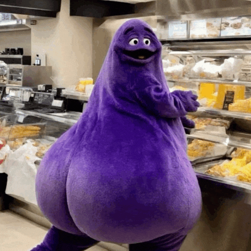 a purple cartoon character is standing in front of a display case of food