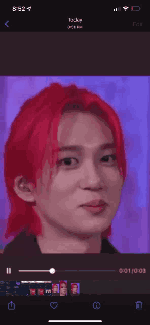 a phone screen shows a video of a young man with red hair