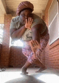 a woman in a turban is standing on a porch with her hands on her face .