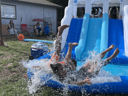 a person is falling into an inflatable pool with a water slide