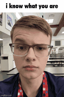 a young man wearing glasses and a lanyard that says ' i know what you are ' on it