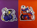 two stickers of a dragon and a rabbit are on a purple and orange surface .