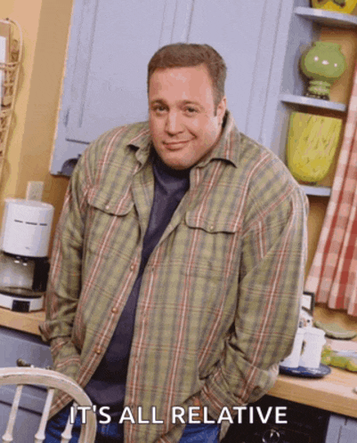 a man in a plaid shirt is standing in a kitchen with the words it 's all relative above him