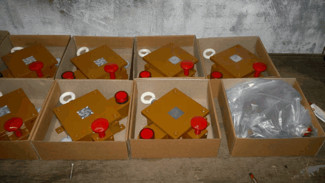 several boxes of yellow boxes with red knobs on top