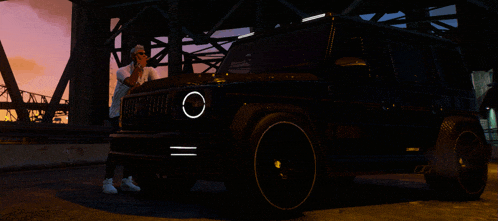 a man stands in front of a black car with a circle in the headlight