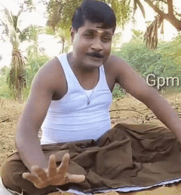 a man in a white tank top is sitting on the ground with his hands outstretched and the word gpm in the background