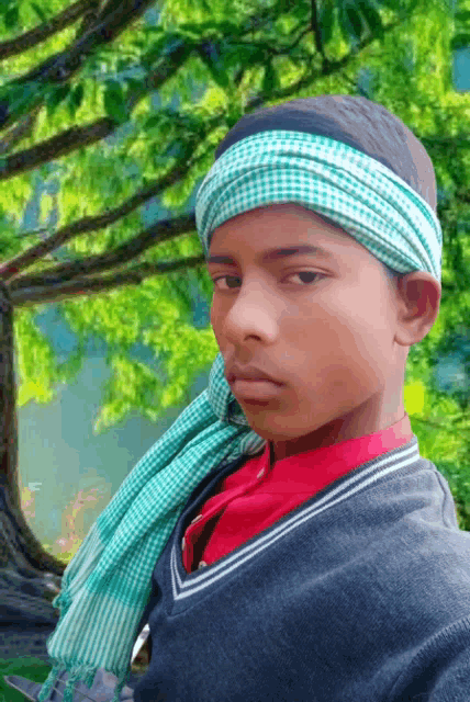 a young boy wearing a green and white head scarf