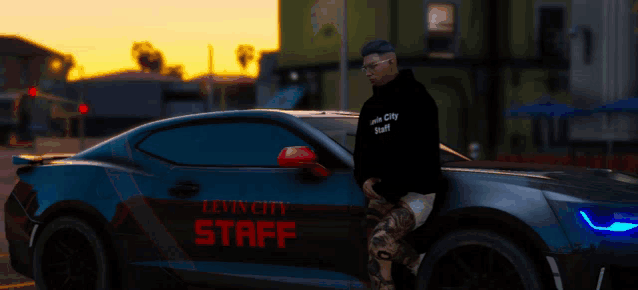 a man leans against a car that says lovin city staff on the side